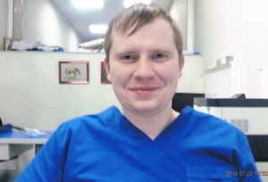 на фото молодой врач онколог в хирургическом костюме, зовут Москвичев Илья Игоревич